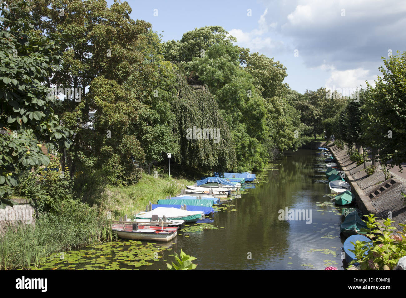 Small private boats parked along a canal in the old walled & fortified city of Naarden, Netherlands. Stock Photo