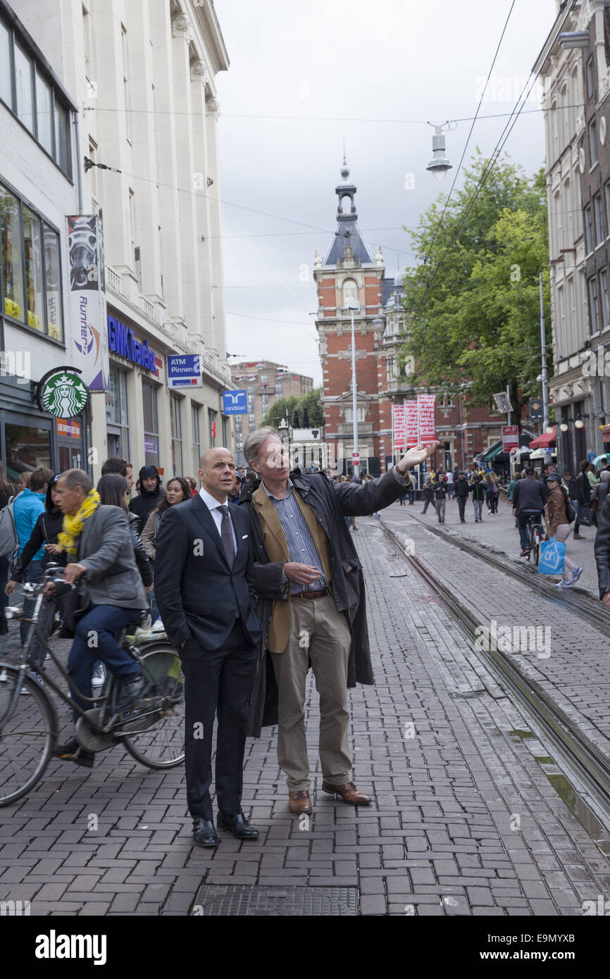Two men conversing on the street along the tram line in Amsterdam ...