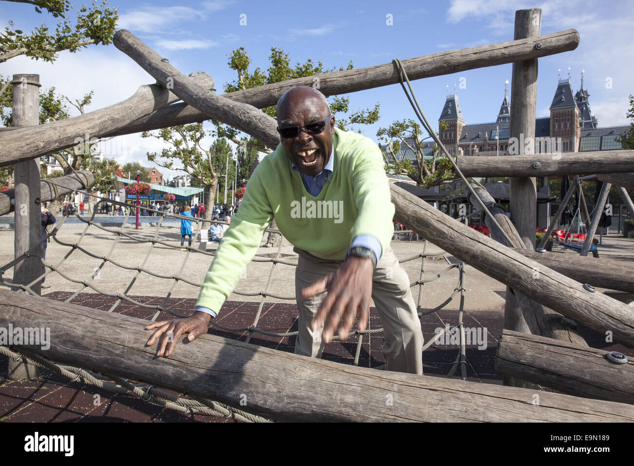Man has a childlike moment on a playground in Amsterdam, Netherlands. Stock Photo