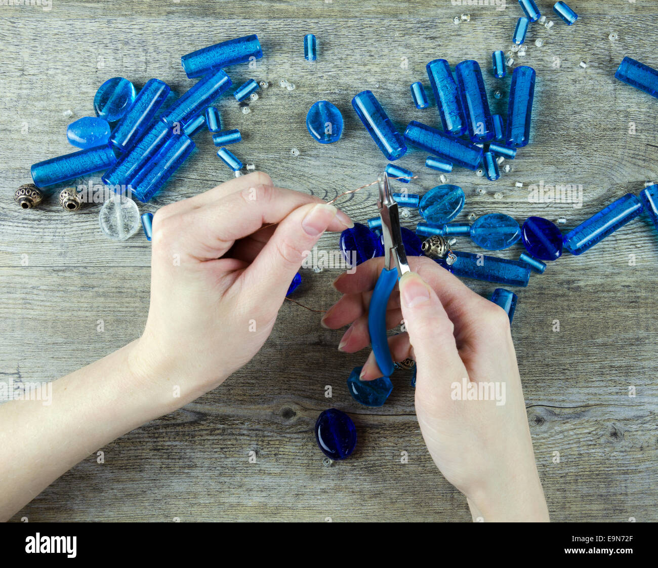 Woman's hands making working with glass beads Stock Photo