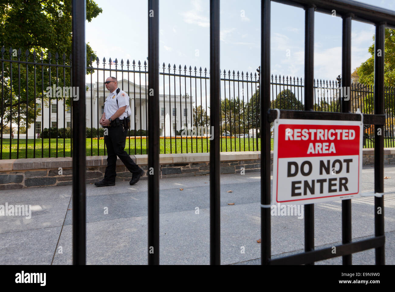 Secret Service police officer behind barricades placed in front of the White House fence - Washington, DC USA Stock Photo