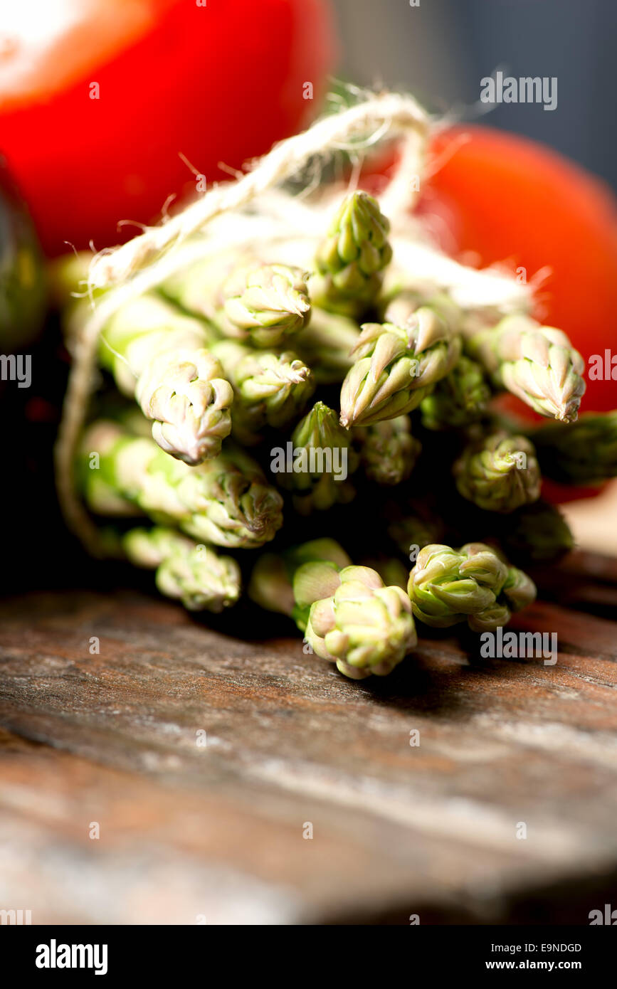 tomatoes asparagus on wooden table close up Stock Photo