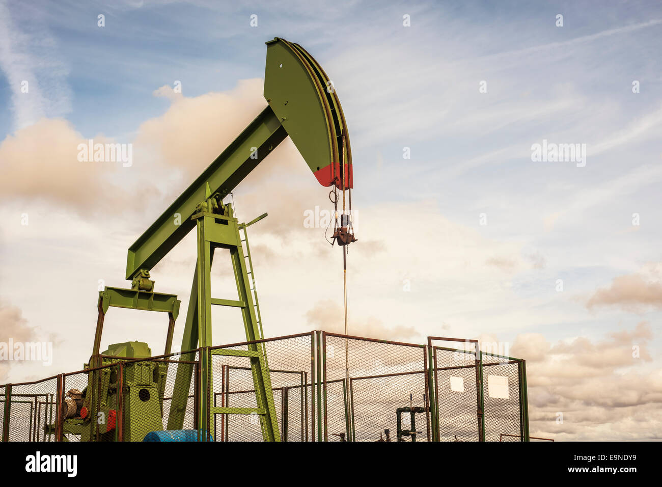 oil rig pumping on cloudy sky background Stock Photo