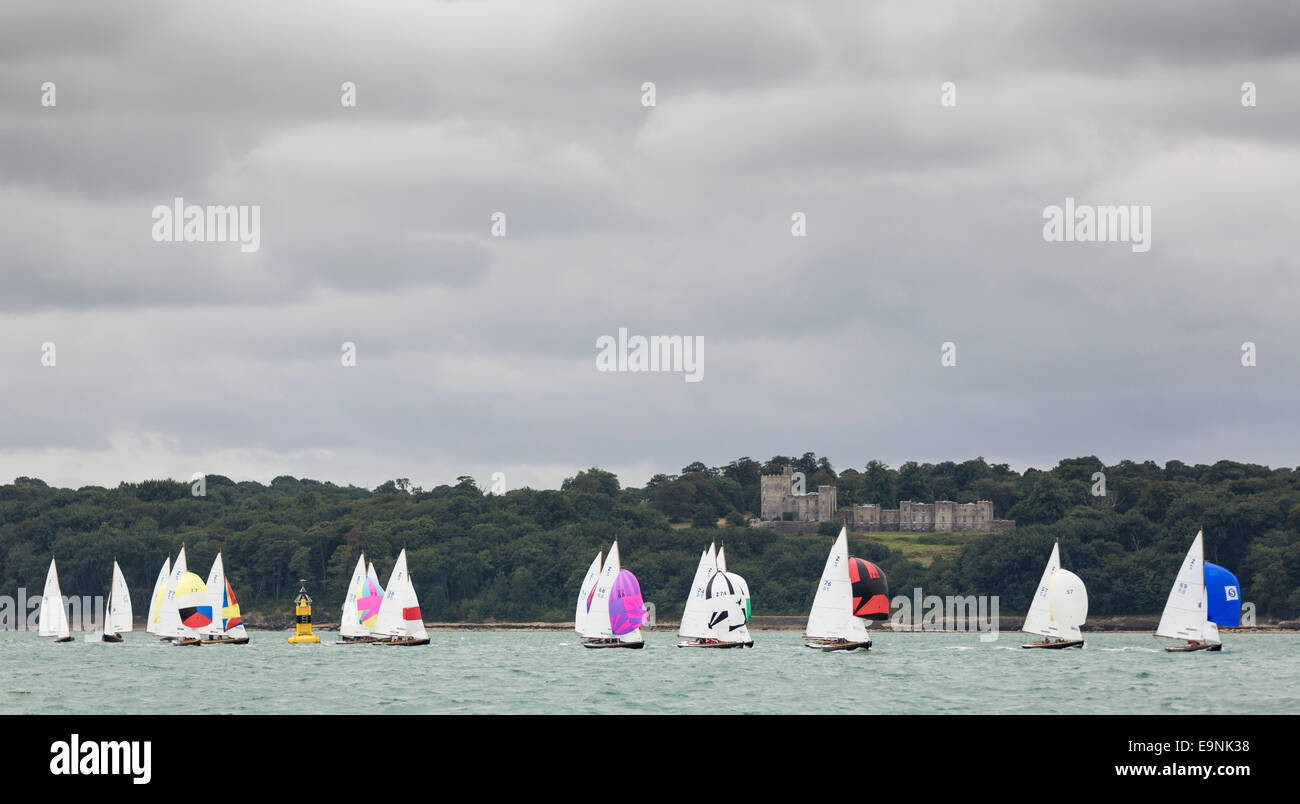 The Victory class fleet pass Norris Castle while racing under spinnakers during Aberdeen Asset Management Cowes Week. The event  Stock Photo