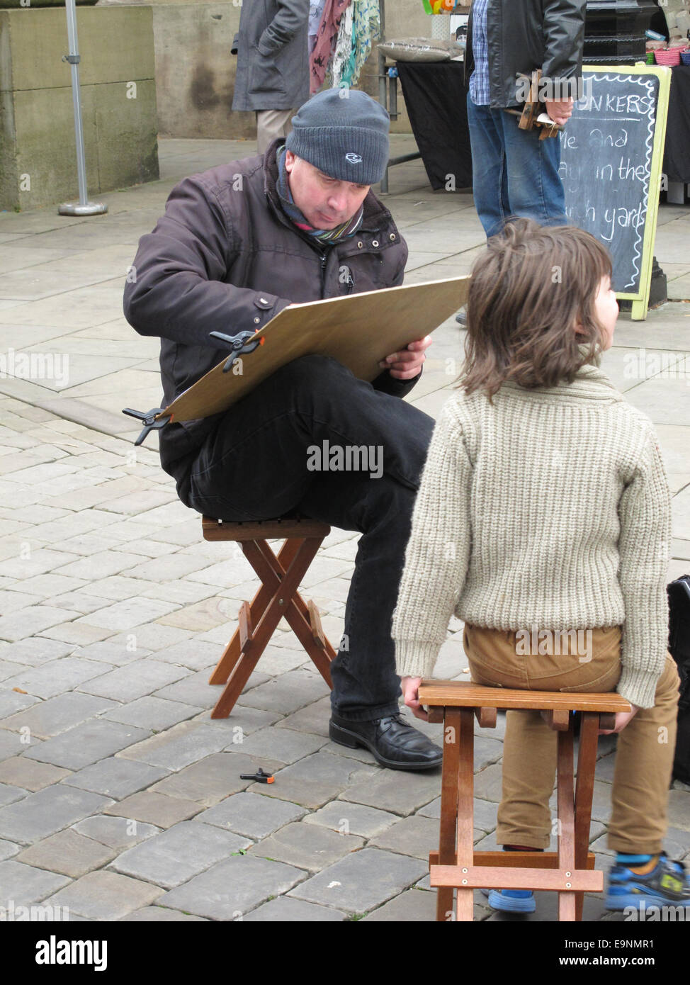 Outdoor portrait artist drawing a child at the monthly traditional Macclesfield treacle market held in the town centre. Stock Photo