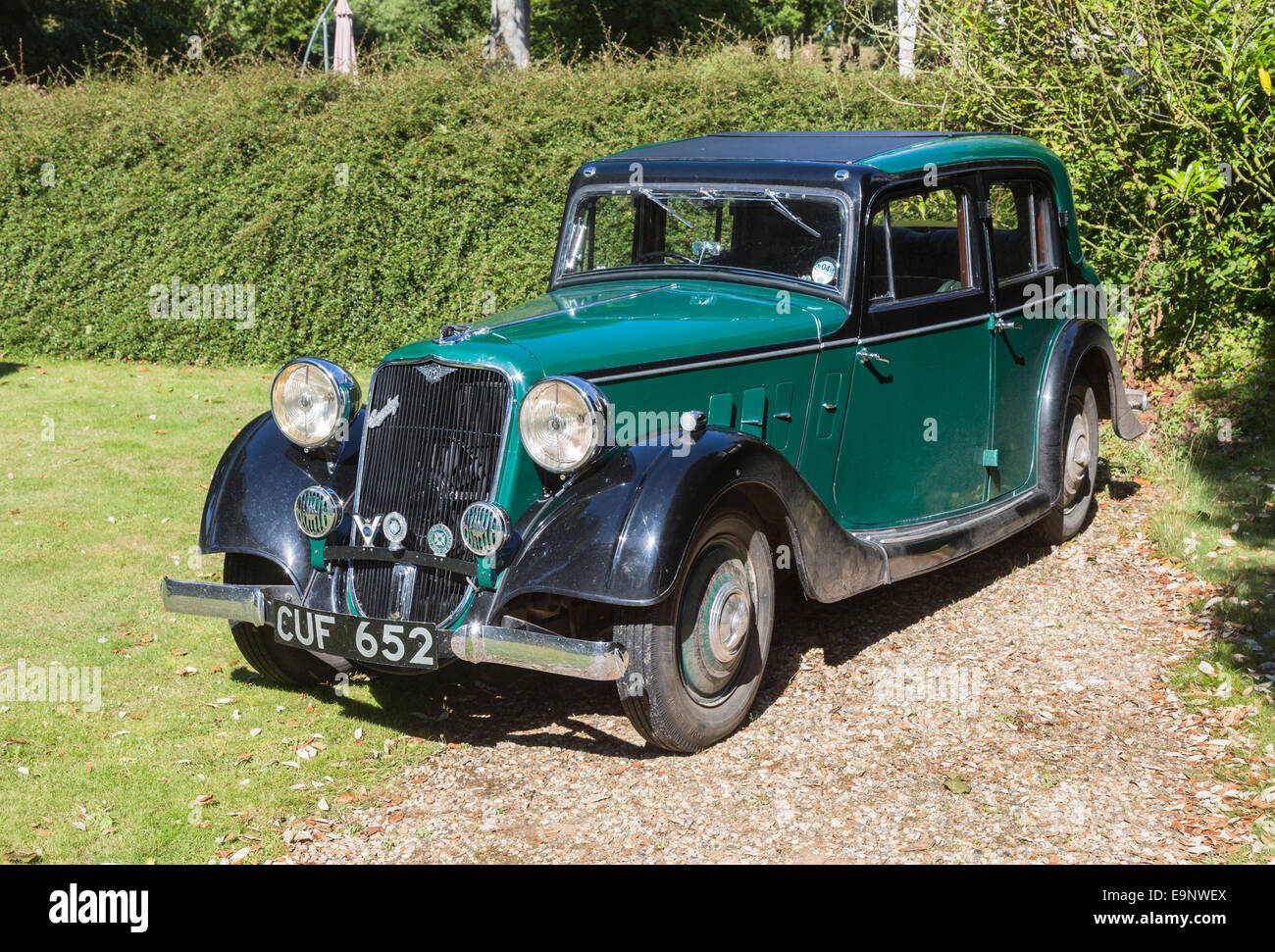 Classic vintage green Crossley car with large headlamps parked outside on grass in Sheringham, Norfolk, UK on a sunny day in summer Stock Photo