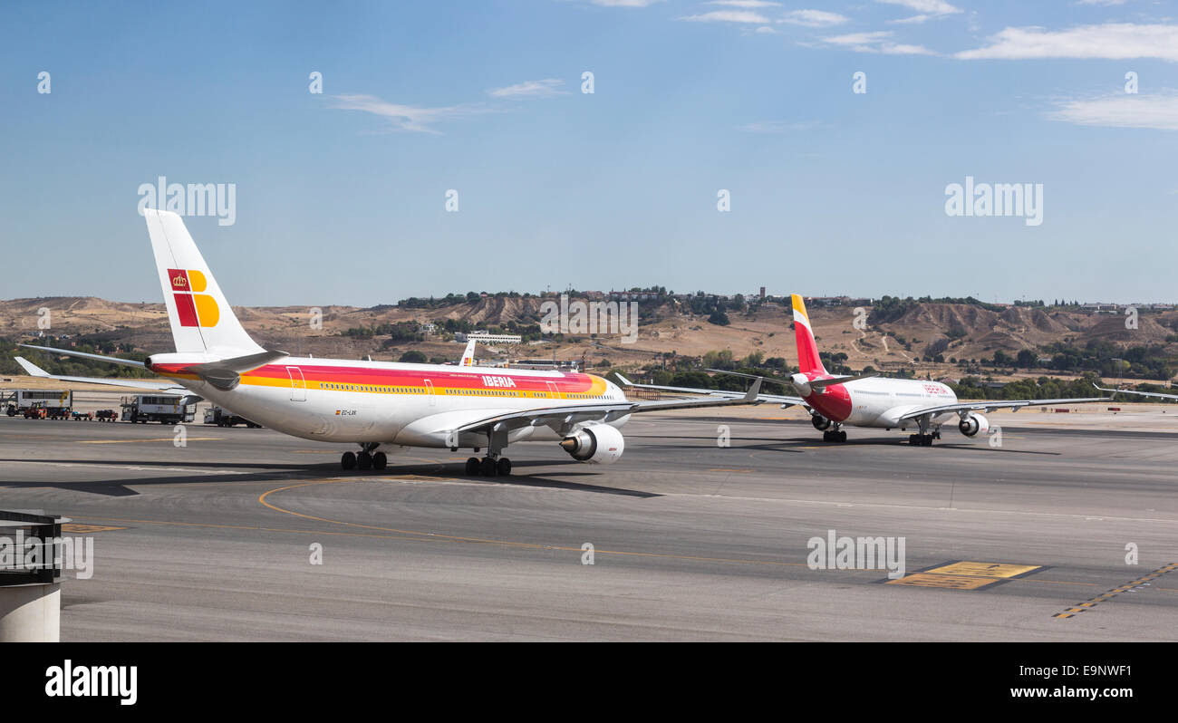 Iberia airline jets line up on the runway waiting to take off from Aeropuerto Madrid Barajas (Madrid Airport) Stock Photo