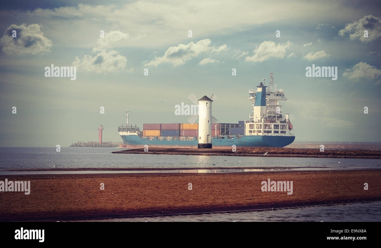 Retro style picture of windmill and ship leaving port. Stock Photo