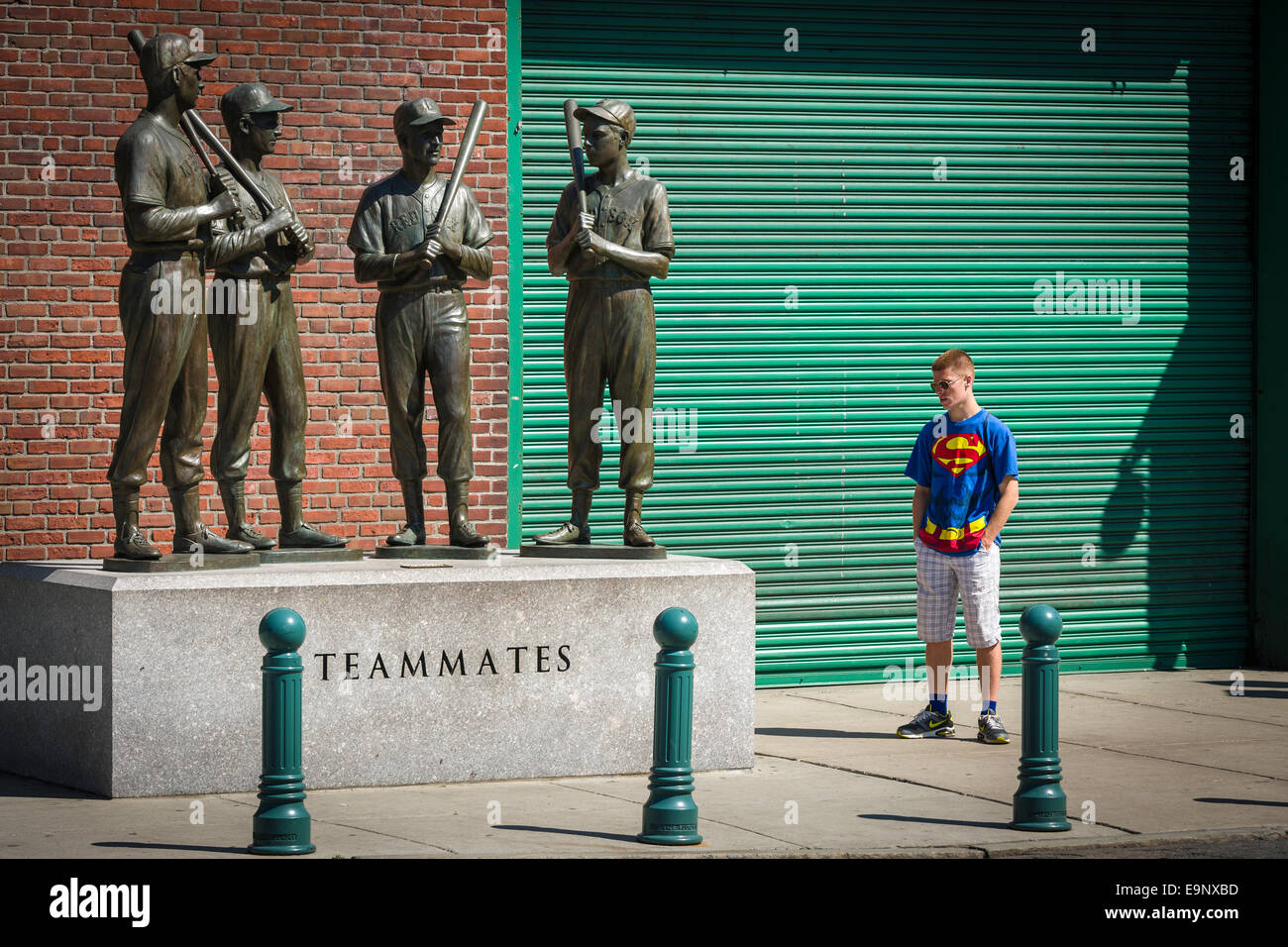 'Superman' studies the Teammates Statue sited outside the Boston Red Sox Stadium at Fenway Park in Boston, Massachusetts - USA. Stock Photo
