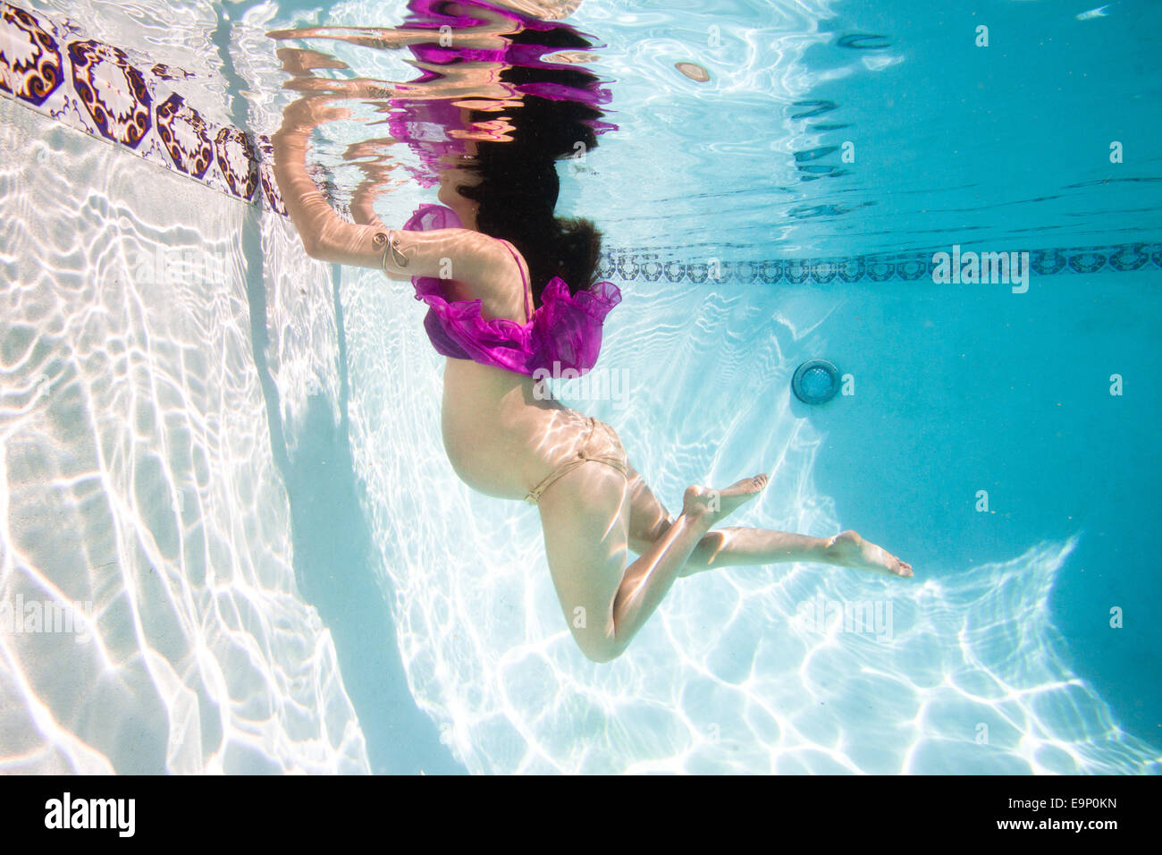 Pregnant woman going for a swim in her pool for exercise. Stock Photo