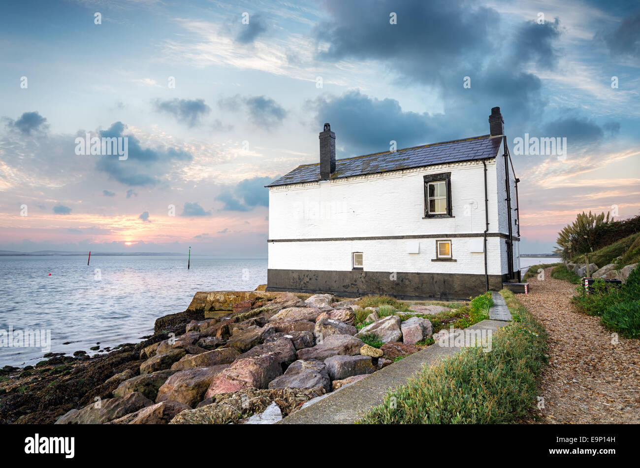 Sunrise over a cottage on the beach Stock Photo