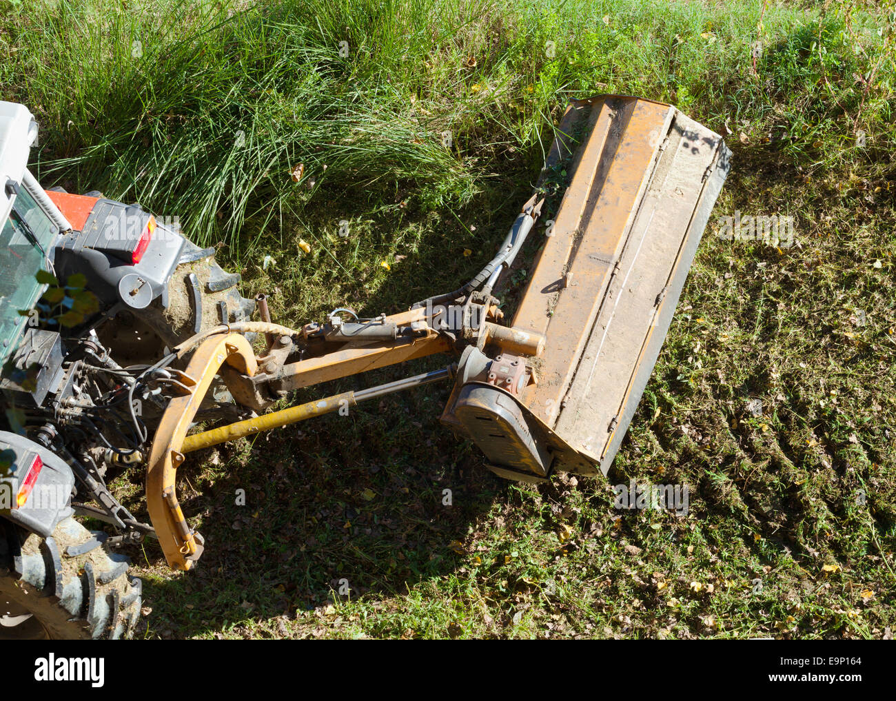 Industrial tractor with mowing for maintenance of the river banks. Stock Photo