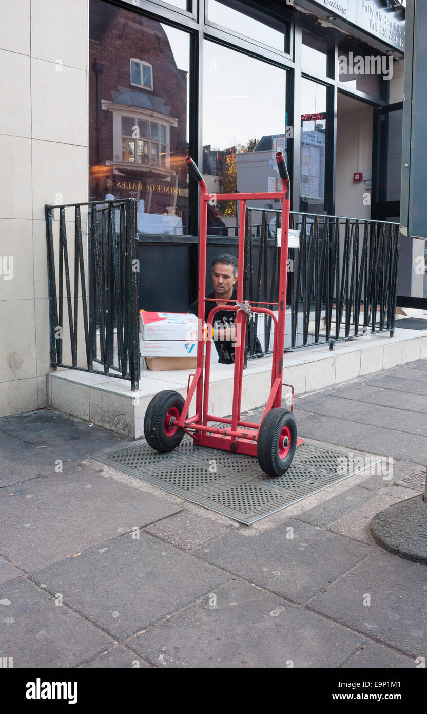 A male delivering food supplies to a restaurant with a sack trolley Stock Photo
