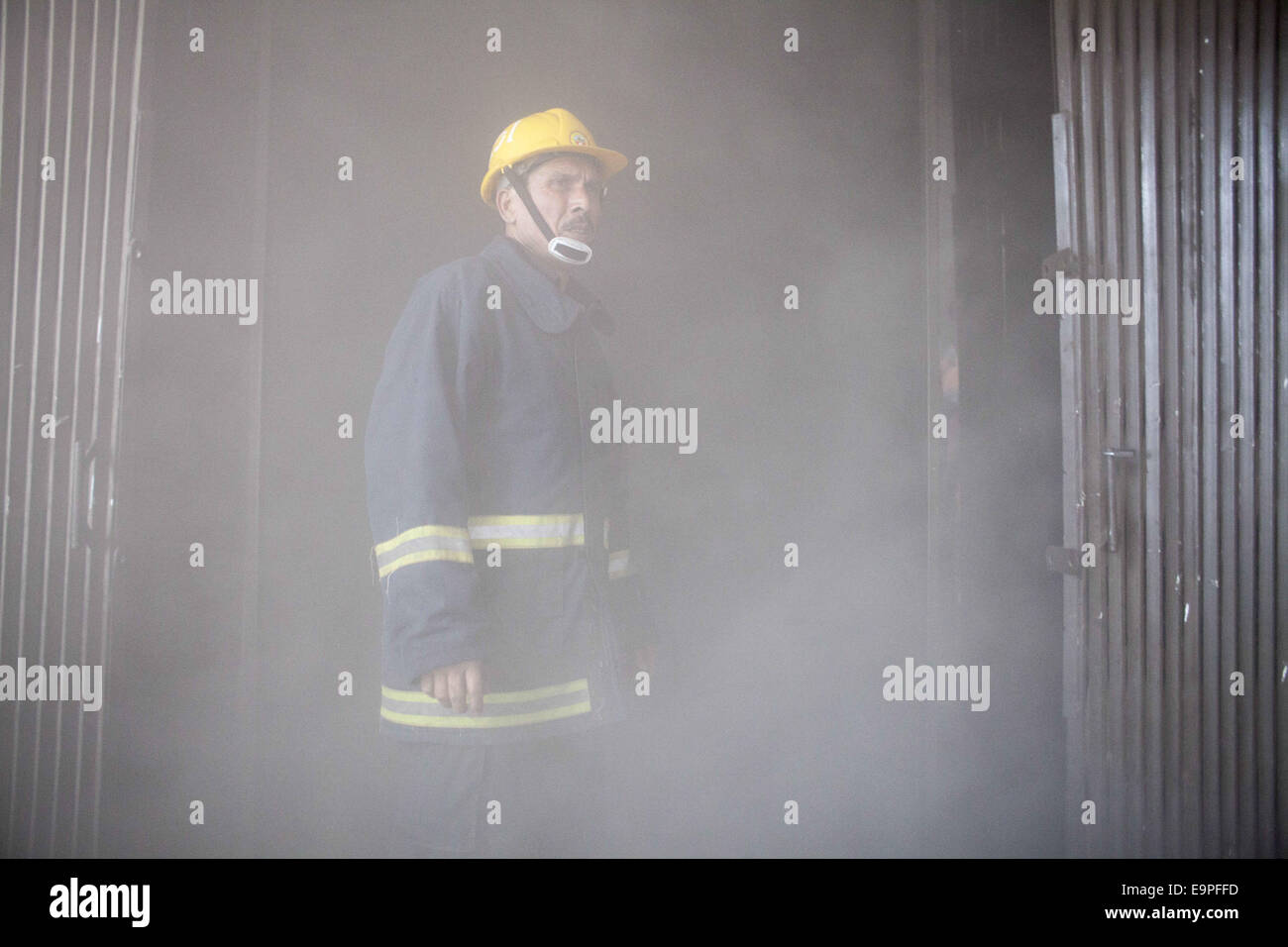 Dhaka, Bangladesh. 31st Oct, 2014. A fire man preparing himself to enter inside the fired building.A devastating fire has broken out in the office of Bangla national daily Amar Desh housed at Bangladesh Steel and Engineering Corporation (BSEC) building in the capital's Kawran Bazar.Fire service sources said a total of 20 fire fighting units rushed to the scene, and are trying to bring the blaze under control.Earlier on Feb 26, 2007, offices of 10 institutions including media units the NTV, RTV and Amar Desh were destroyed in a fire incident at the same building. (Credit Image: © Zakir Hoss Stock Photo