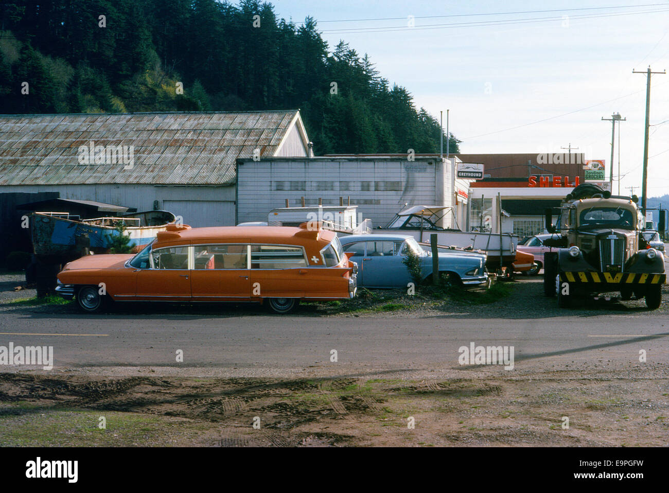 Cadillac Miller Meteor station wagon ambulance and derelict car wrecks at a garage in Gardiner Oregon USA 1977  KATHY DEWITT Stock Photo