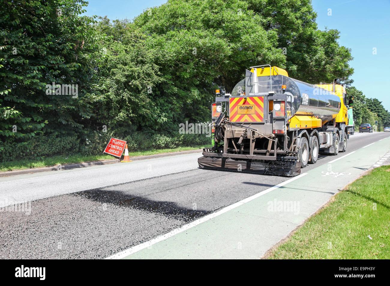 A lorry or truck tarmacing or laying tarmac on a main road Stoke-on-Trent, Staffordshire, England, UK Stock Photo
