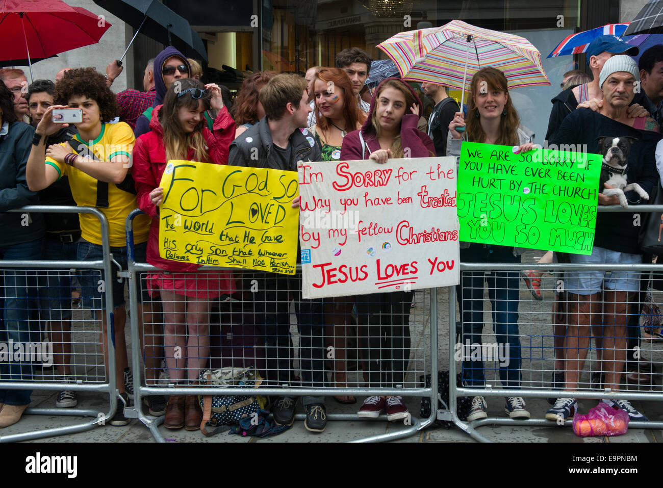 Young Christians holding placards apologising for the Church's treatment of gay people, whilst watching the Pride in London parade 2014, London, England Stock Photo