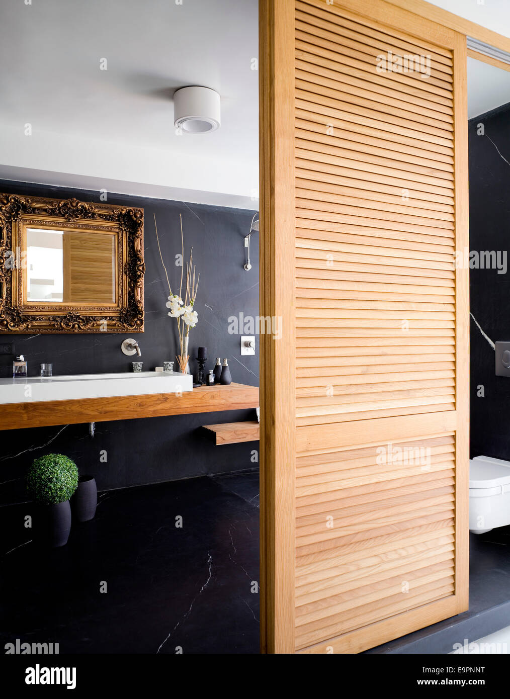 Bathroom behind sliding wooden louvered doors in Hilit home, Israel. Stock Photo