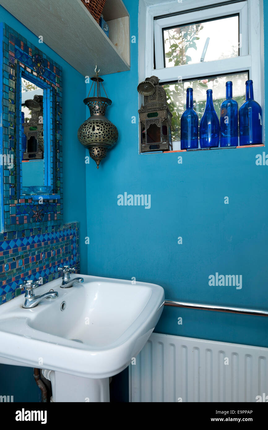 Blue bottles and Moroccan incense burner with mirror and sink in renovated  terraced house, Kingston upon Thames, Surrey, England, UK Stock Photo -  Alamy