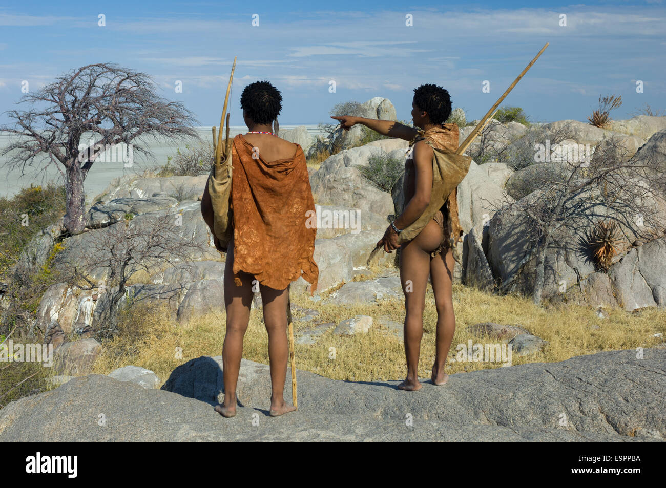 San Bushmen standing on the granite mass of Kubu Island (Lekhubu), looking out to the the Makgadikgadi Pan, Botswana Stock Photo