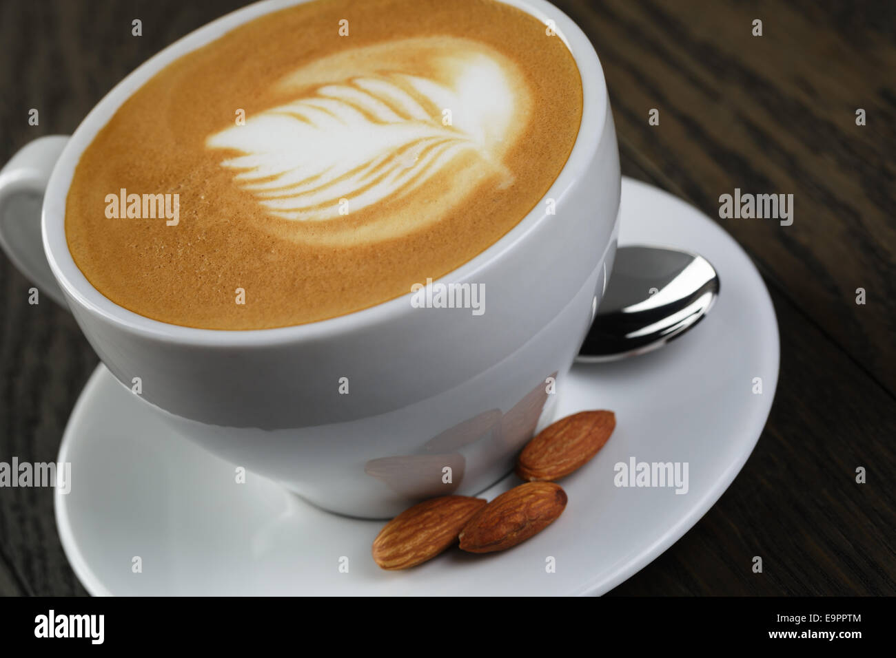 cup of fresh cappuccino with latte art, on oak table Stock Photo