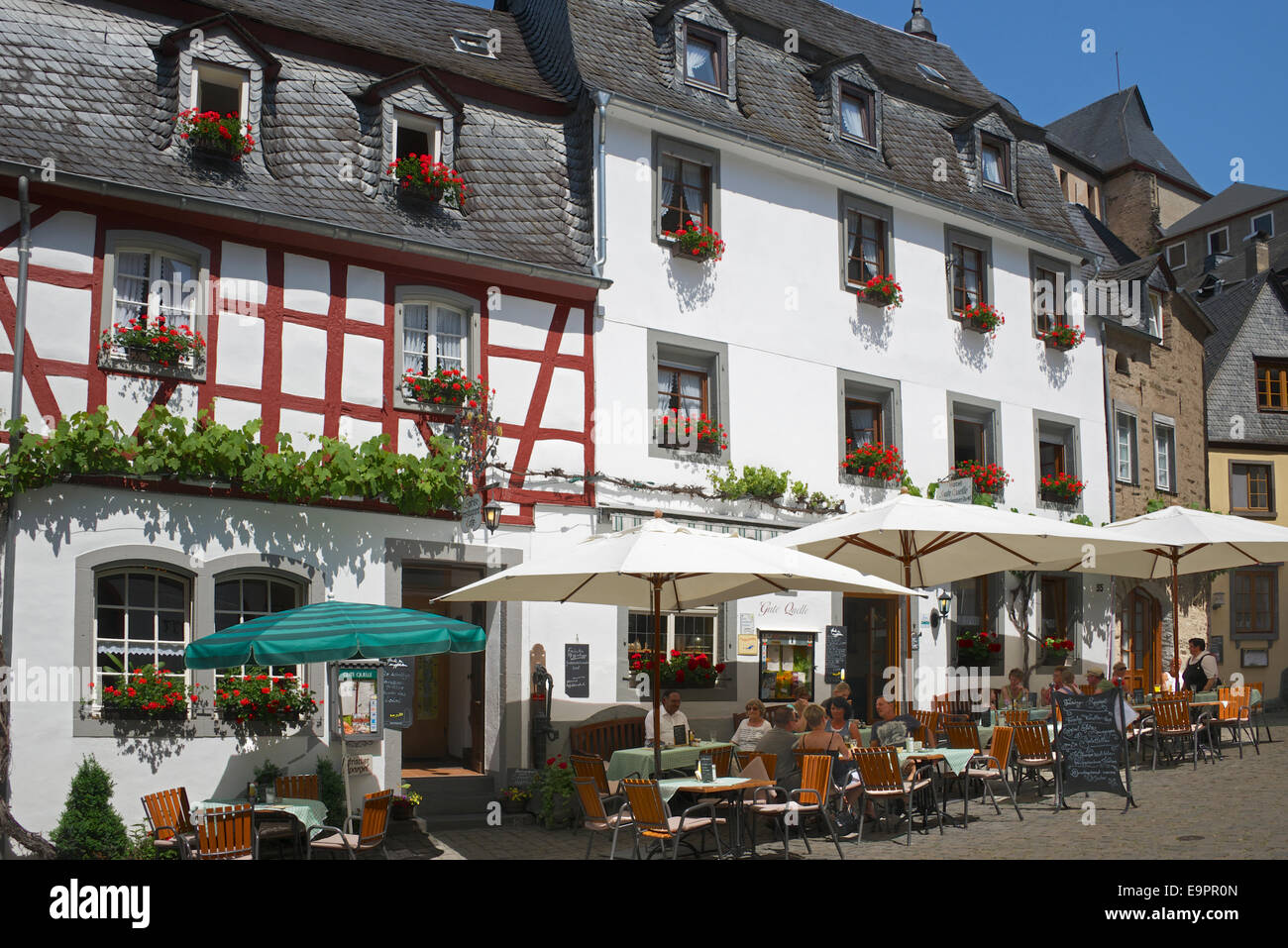 People enjoying the sunshine at outdoor cafes medieval town of Beilstein Moselle Valley Germany Stock Photo