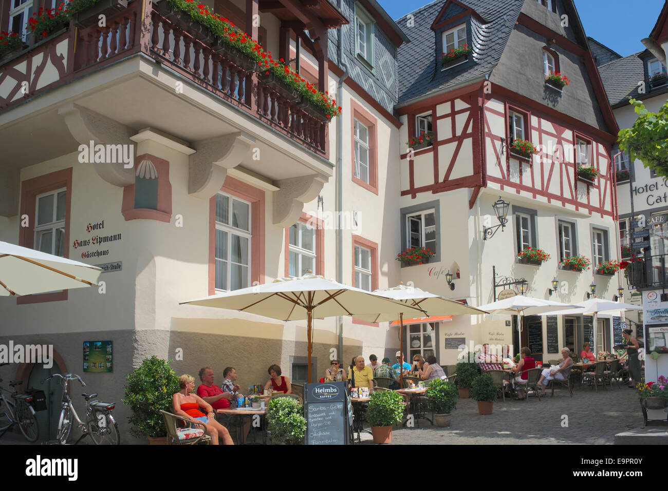 People enjoying the sunshine at outdoor cafes medieval town of Beilstein Moselle Valley Germany Stock Photo