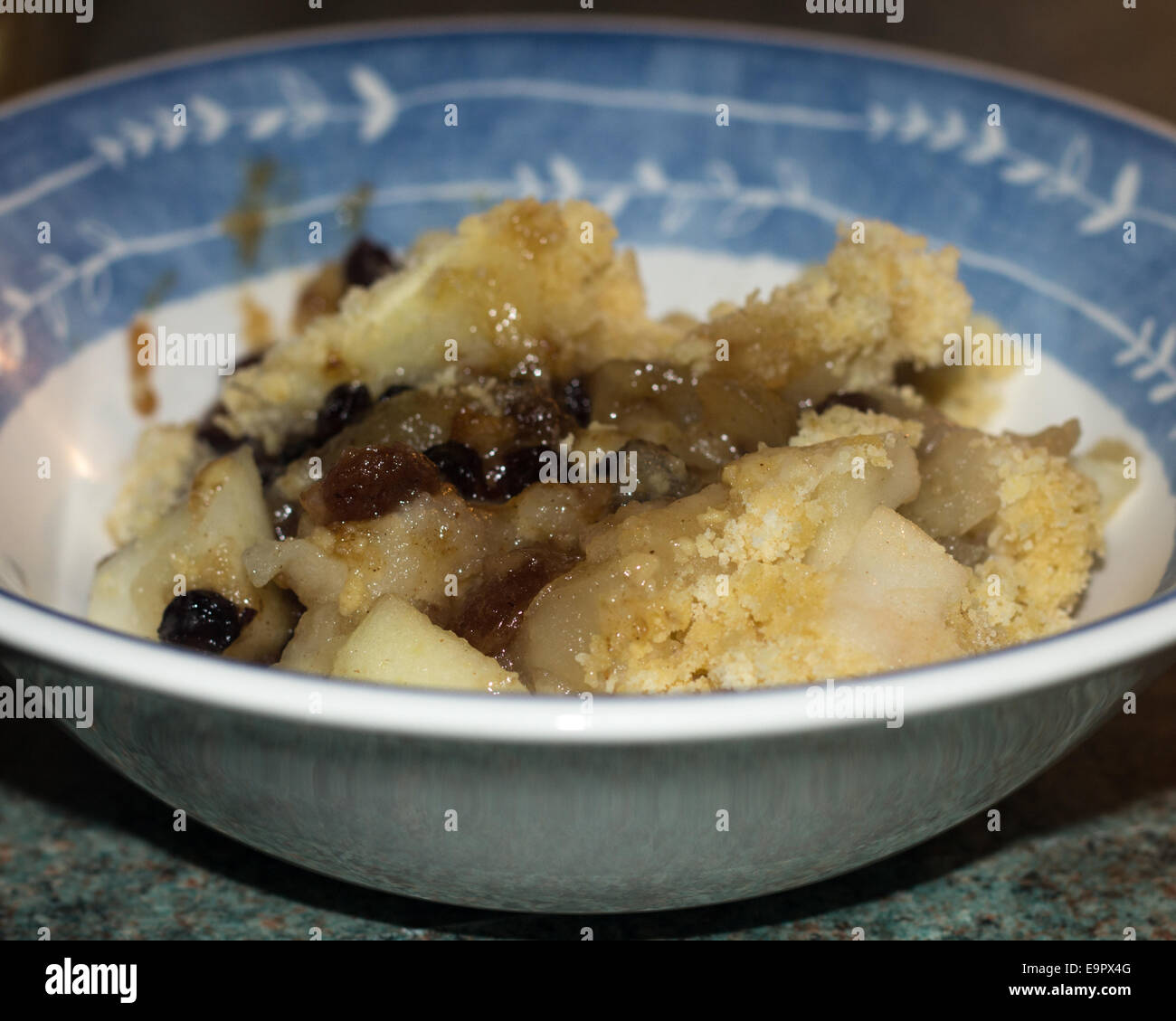 Apple and mince meat crumble pudding in a bowl ready to be eaten Stock ...
