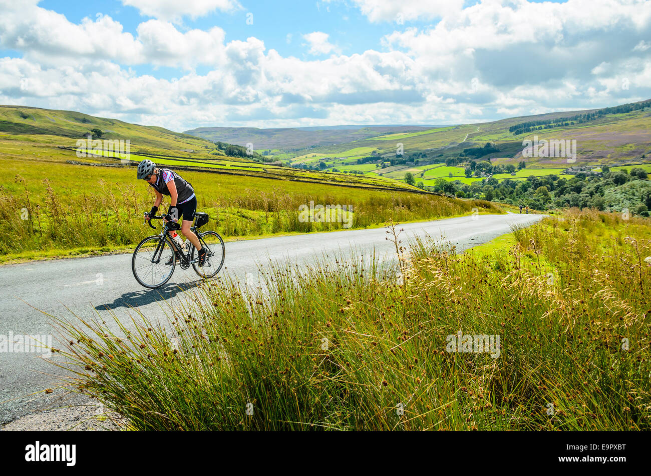 Female cyclist climbing The Stang in the Yorkshire Dales Stock Photo