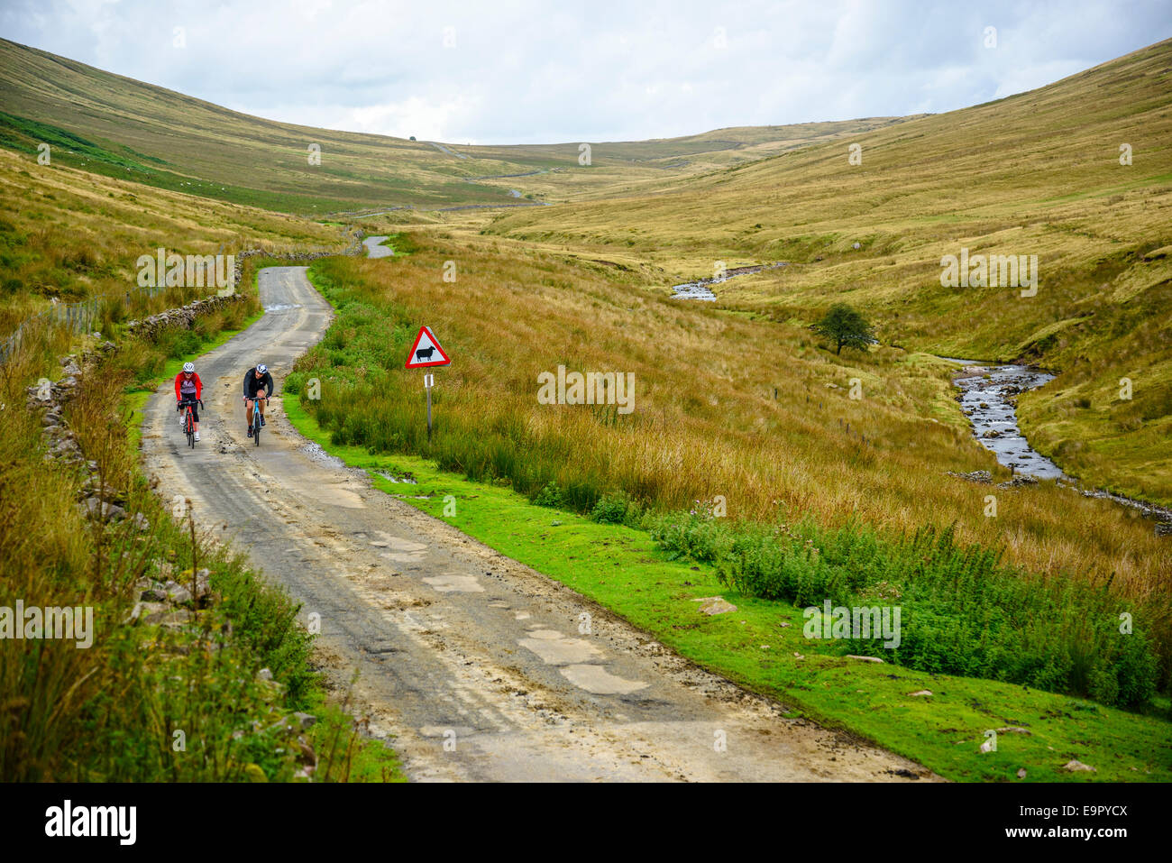 Cyclists on lonely road in valley of Afon Llia in the Brecon Beacons National Park Wales Stock Photo