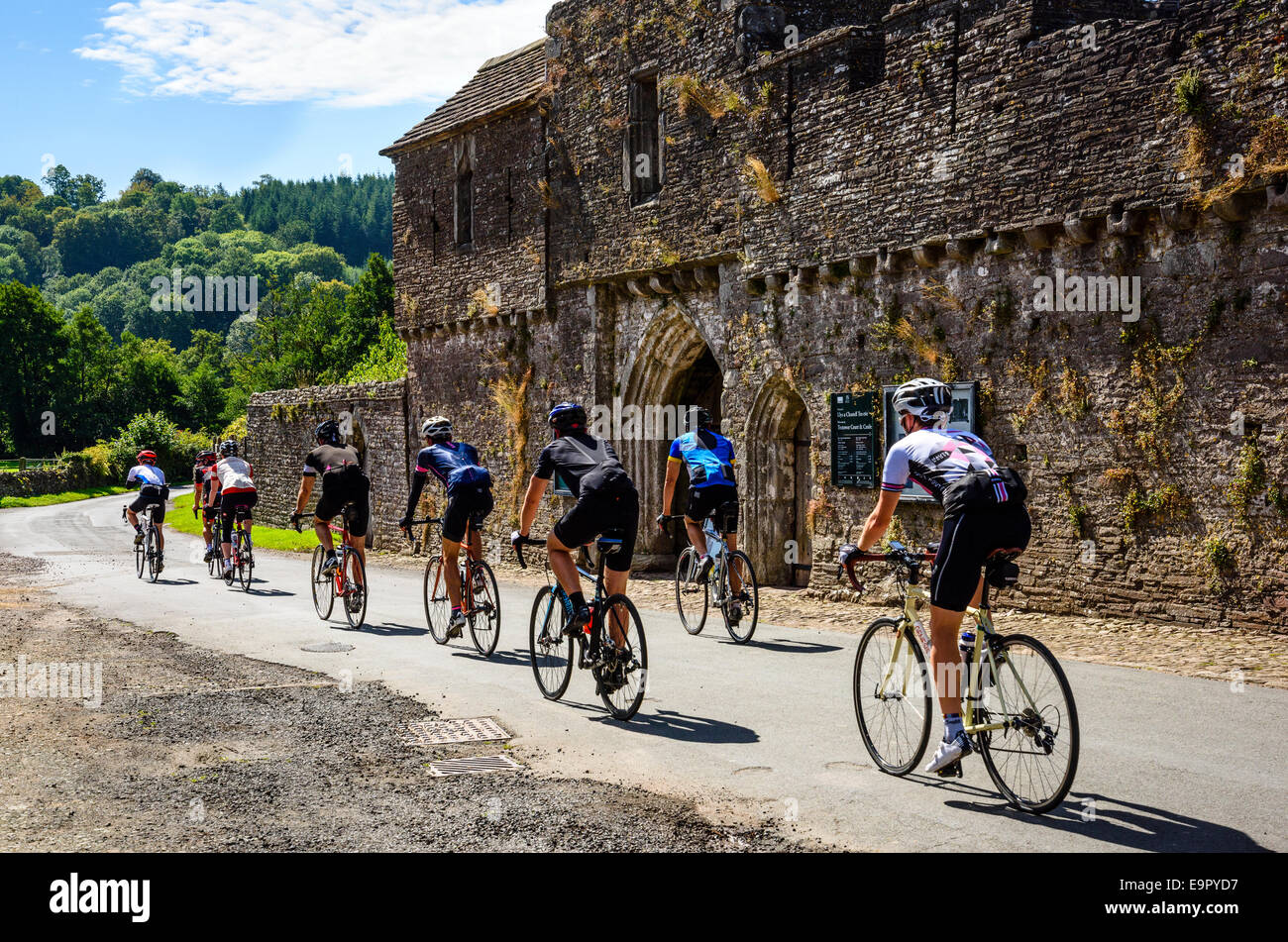 Group of cyclists passing Tretower Court & Castle in the Brecon Beacons National Park Wales Stock Photo