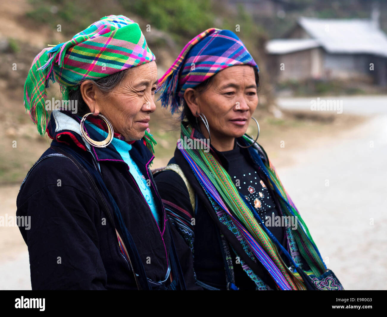 Black Hmong women wearing traditional attire and jewelry standing on the trail to Ta Van village, near Sapa Town, Vietnam. Stock Photo