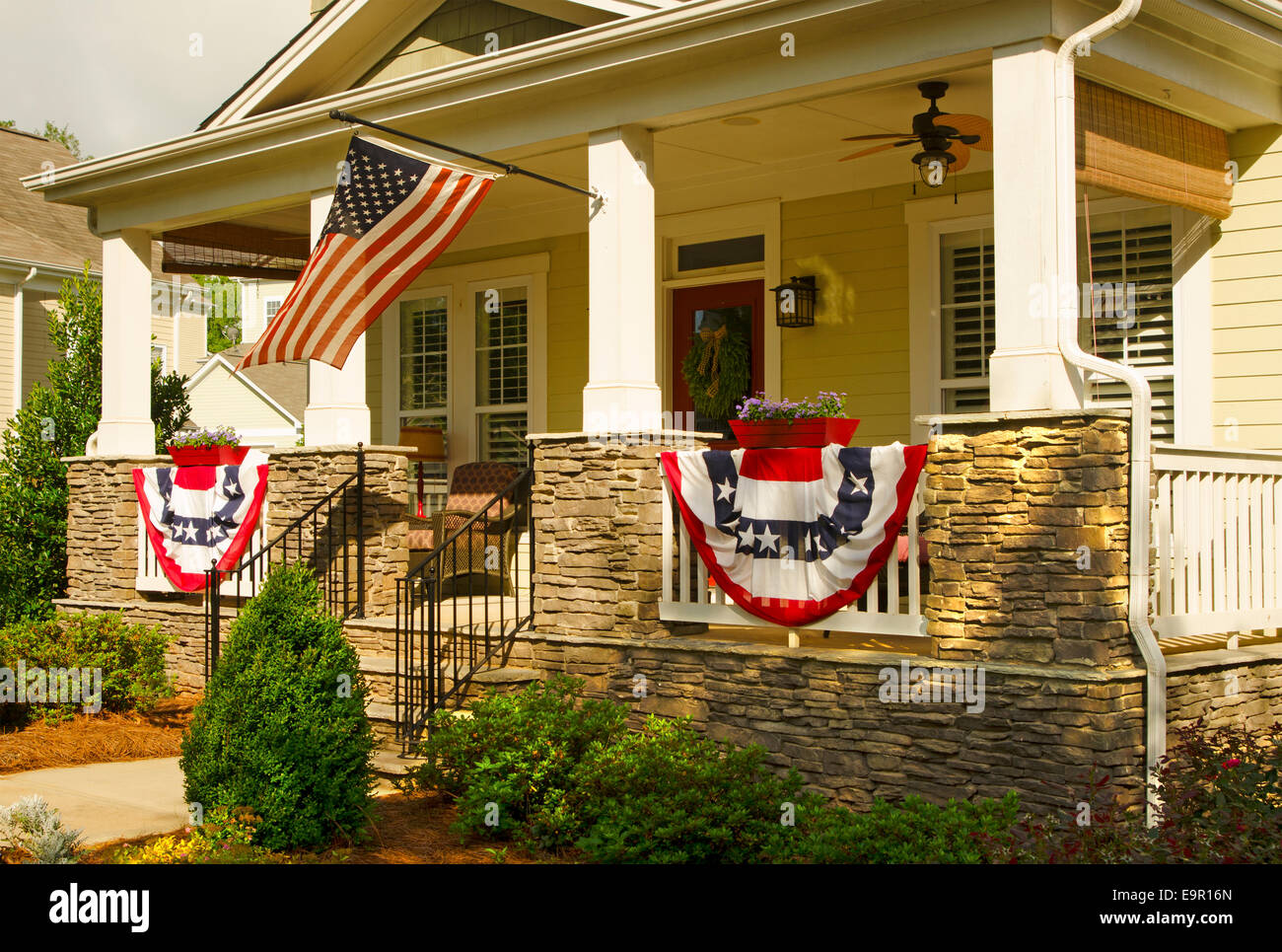 An American Flag and buntings hang from a front porch of an upscale ...