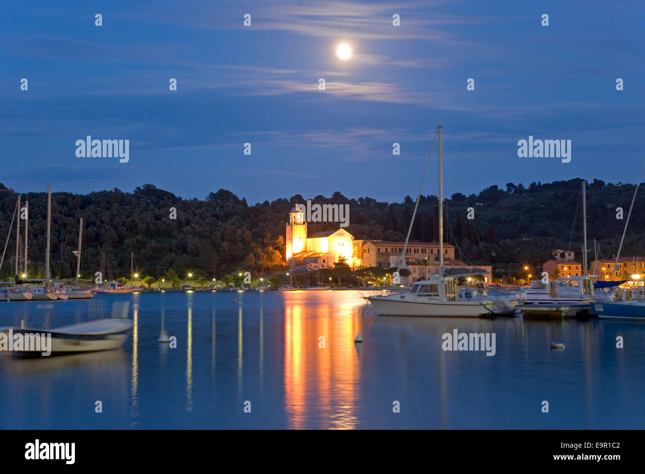 Portovenere, Liguria, Italy. View by moonlight across harbour to the illuminated Santuario di Nostra Signora delle Grazie. Stock Photo