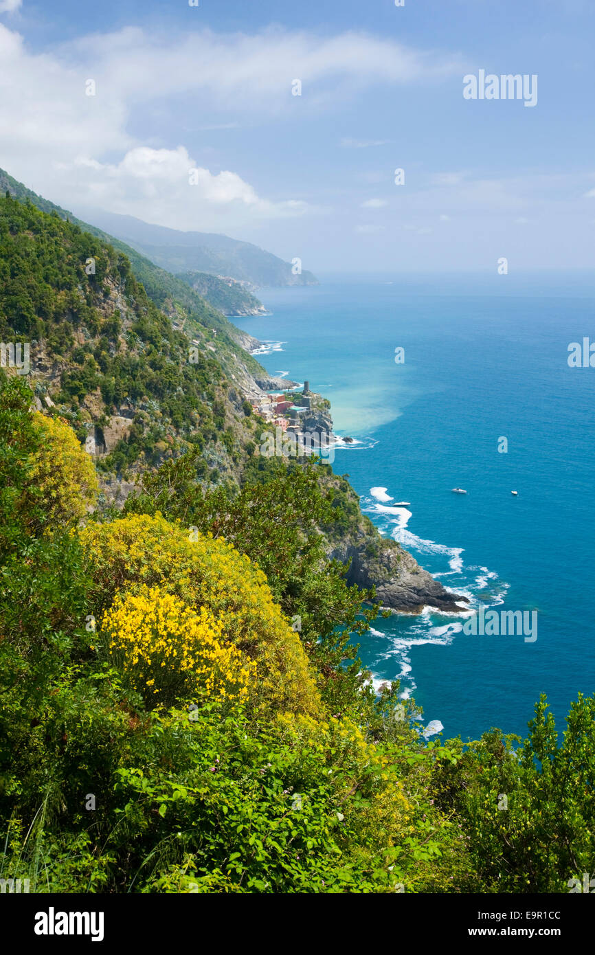 Vernazza, Cinque Terre National Park, Liguria, Italy. View to the distant village from footpath above rugged coast. Stock Photo