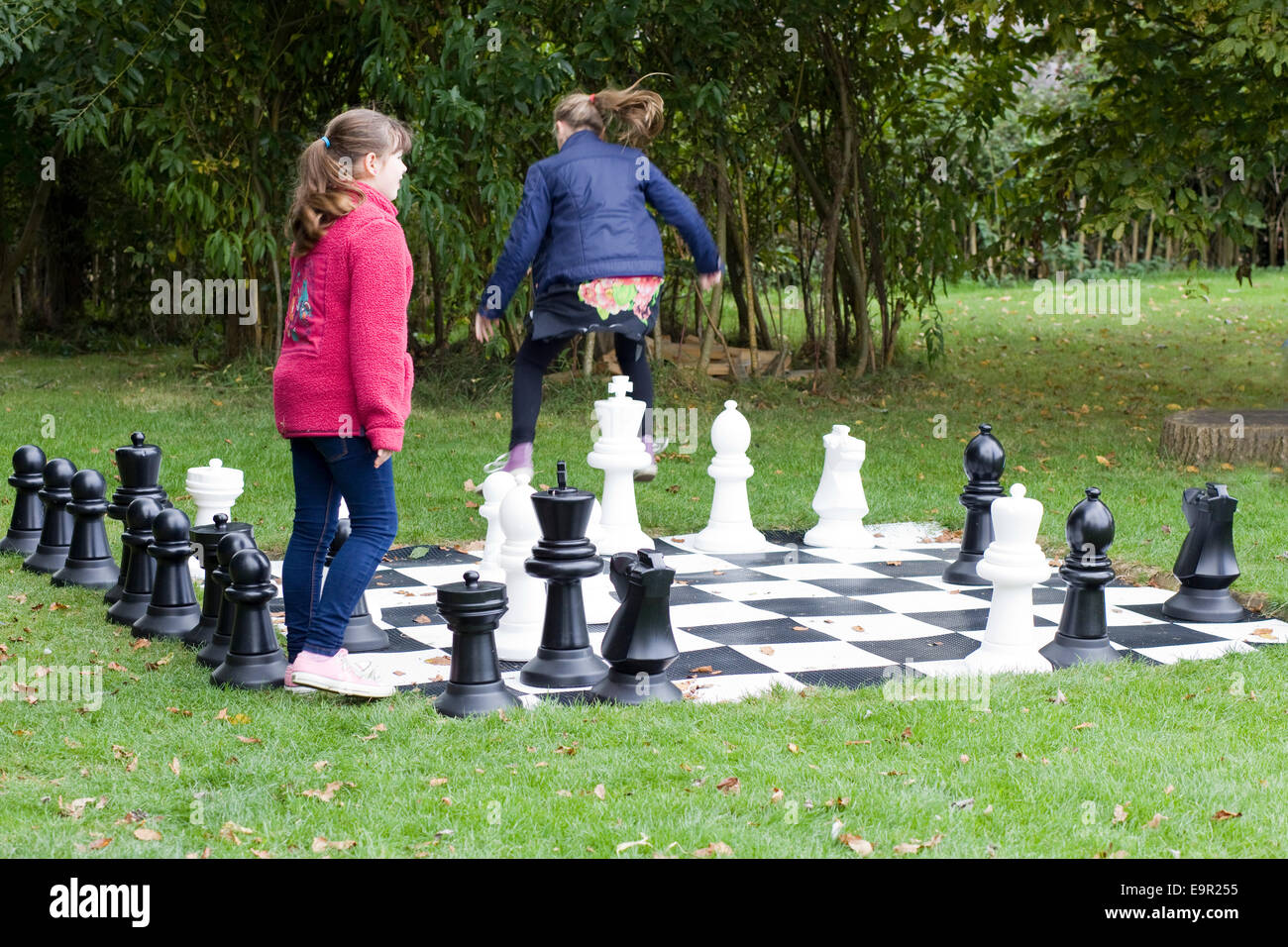 Children playing on a giant garden chess set Stock Photo