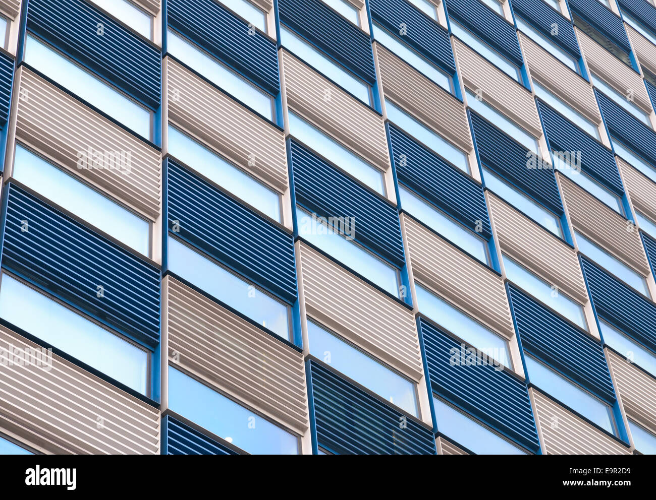 Office facade with ripples in blue and white and reflective windows ...
