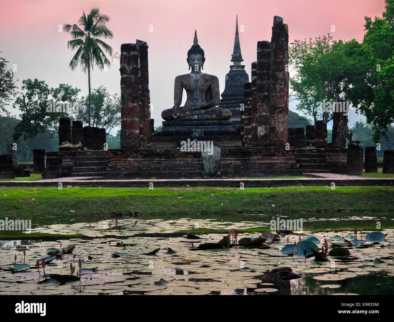 Buddha statue and ruins of Wat Mahathat temple in Sukhothai, Thailand. Stock Photo