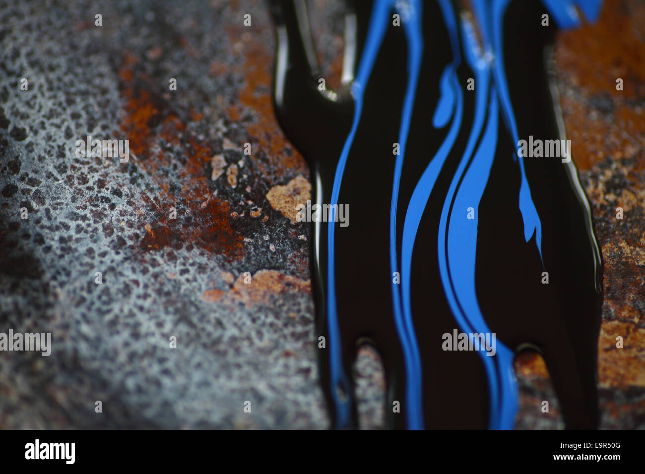 Blue and black paint on a rusted metal surface Stock Photo