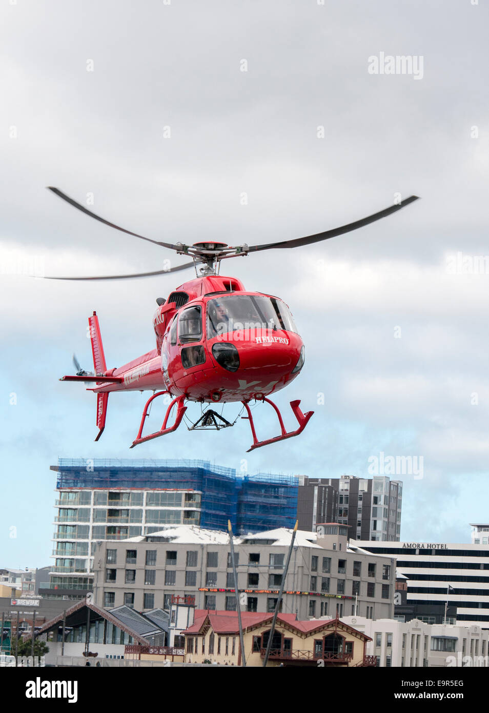 Red Helipro Eurocopter Squirrel Helicopter flying from Queens Wharf, Wellington, New Zealand Stock Photo