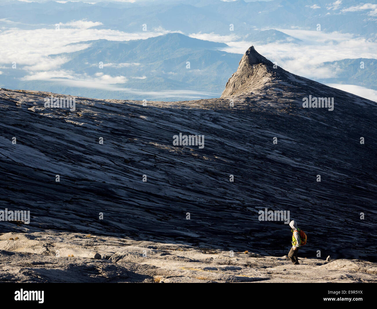 Hiker at the top of Mount Kinabalu, the highest peak in the Malay Archipelago, in Sabah, East Malaysia. Stock Photo