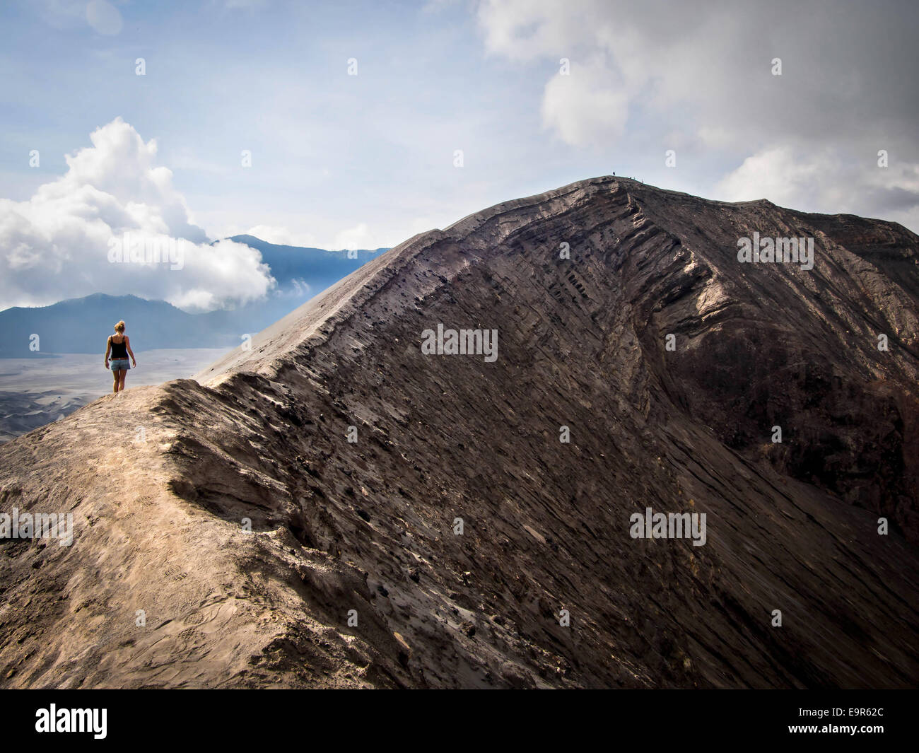 Hiker walking around the rim of Gunung Bromo volcano in East Java, Indonesia. Stock Photo
