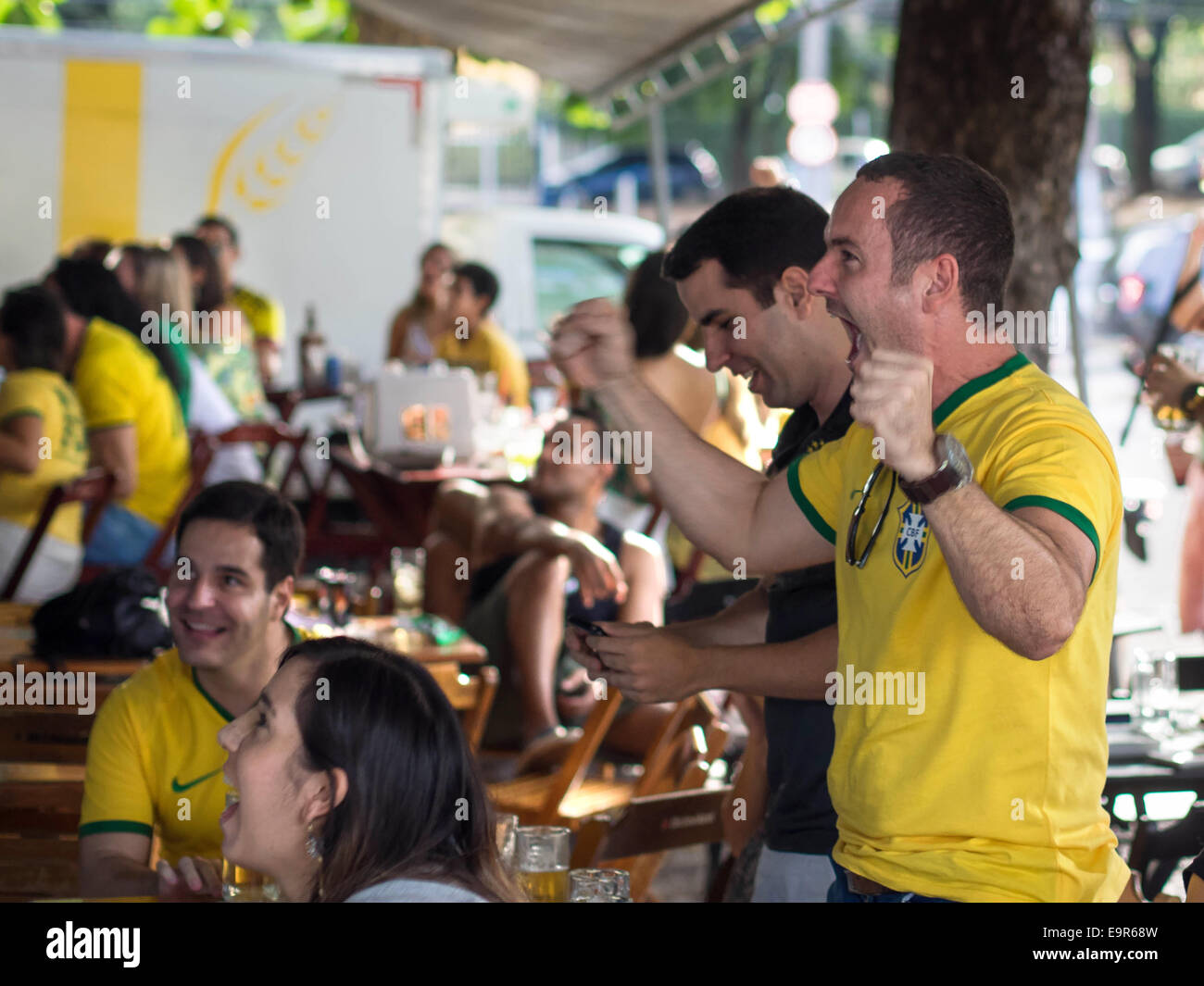 Cheerful Brazil fans celebrating victory at World Cup football match on TV at a bar in Salvador, Bahia, Brazil. Stock Photo