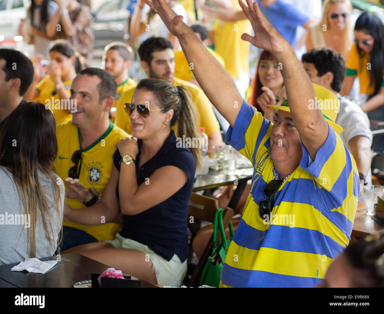 Cheerful Brazil fans watching World Cup football match on TV at a bar in Salvador, Bahia, Brazil. Stock Photo