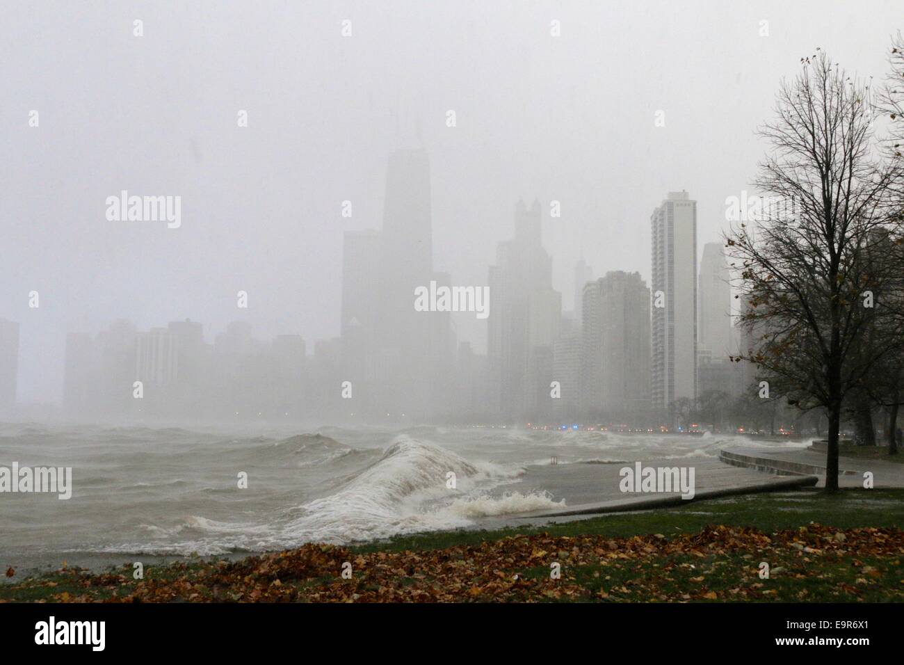Chicago, Illinois, USA. 31st October, 2014. A snow squall during today's gale obscures the buildings of downtown Chicago as a large wave crashes into the seawall. Gale force winds produced waves of over 20 feet as measured at a NOAA weather buoy far out on Lake Michigan. Credit: Todd Bannor/Alamy Live News Stock Photo