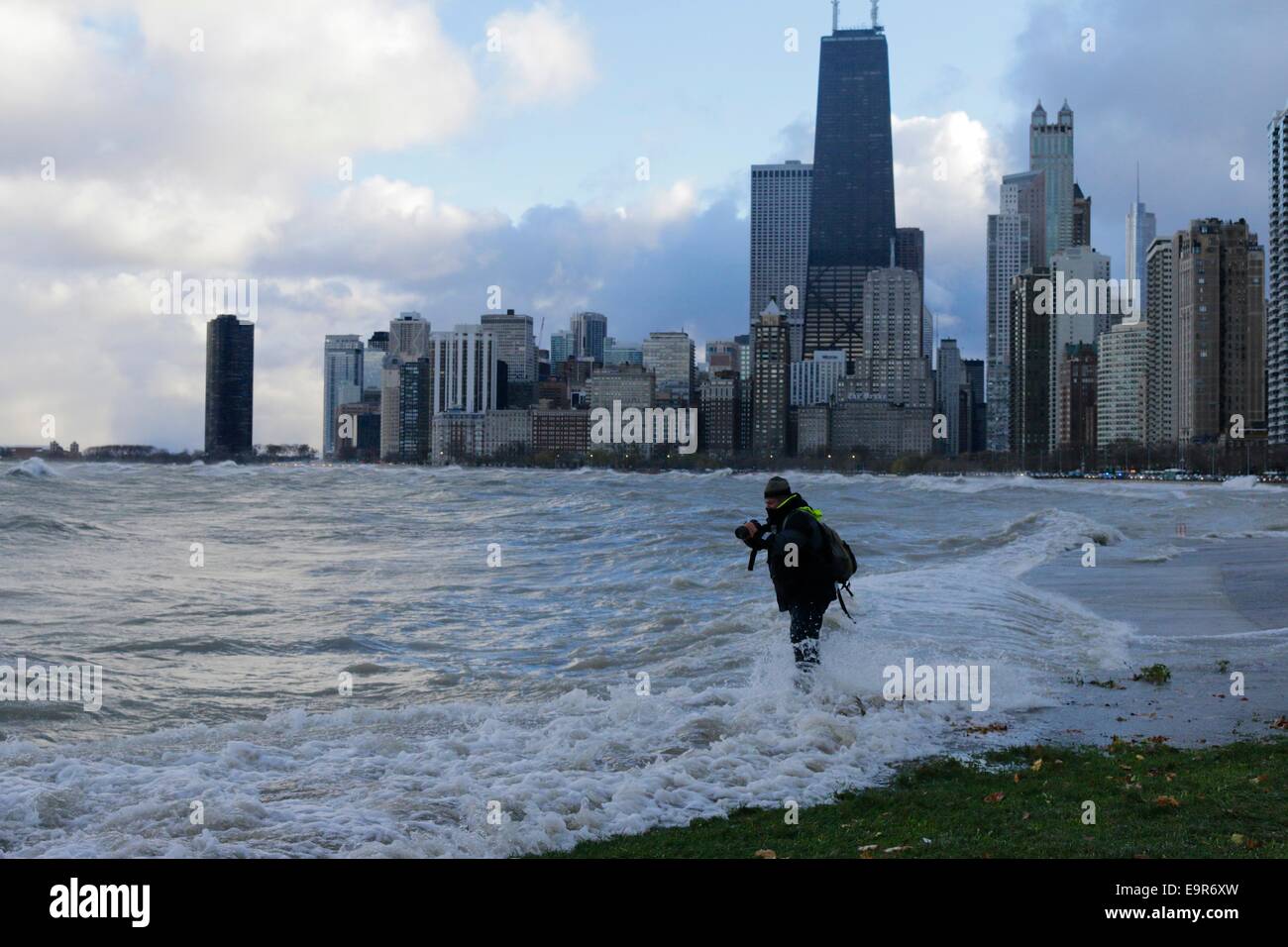 Chicago, Illinois, USA. 31st October, 2014.  A large Lake Michigan wave soaks a photographer who got a bit too close to the action during today's gale. The man beat a hasty retreat out of the danger zone. Gale force winds produced waves of over 20 feet as measured at a NOAA weather buoy far out on the big lake. Credit:  Todd Bannor/Alamy Live News Stock Photo