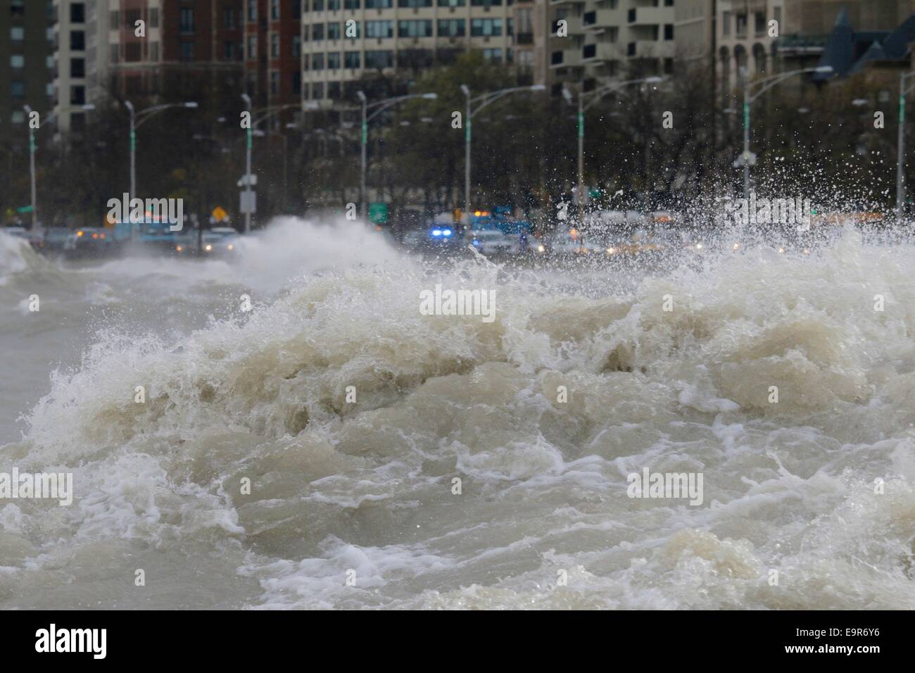 Chicago, Illinois, USA. 31st October, 2014. Huge Lake Michigan waves raised by gale force winds forced the closing of northbound lanes of Lake Shore Drive, seen in the background beyond the raging waters. Gale force winds produced waves of over 20 feet as measured at a NOAA weather buoy far out the big lake. Credit: Todd Bannor/Alamy Live News Stock Photo