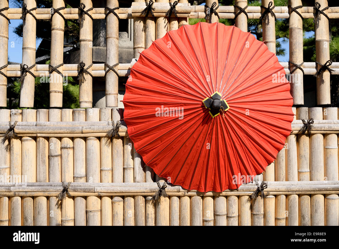 Japanese traditional red umbrella with bamboo fence Stock Photo