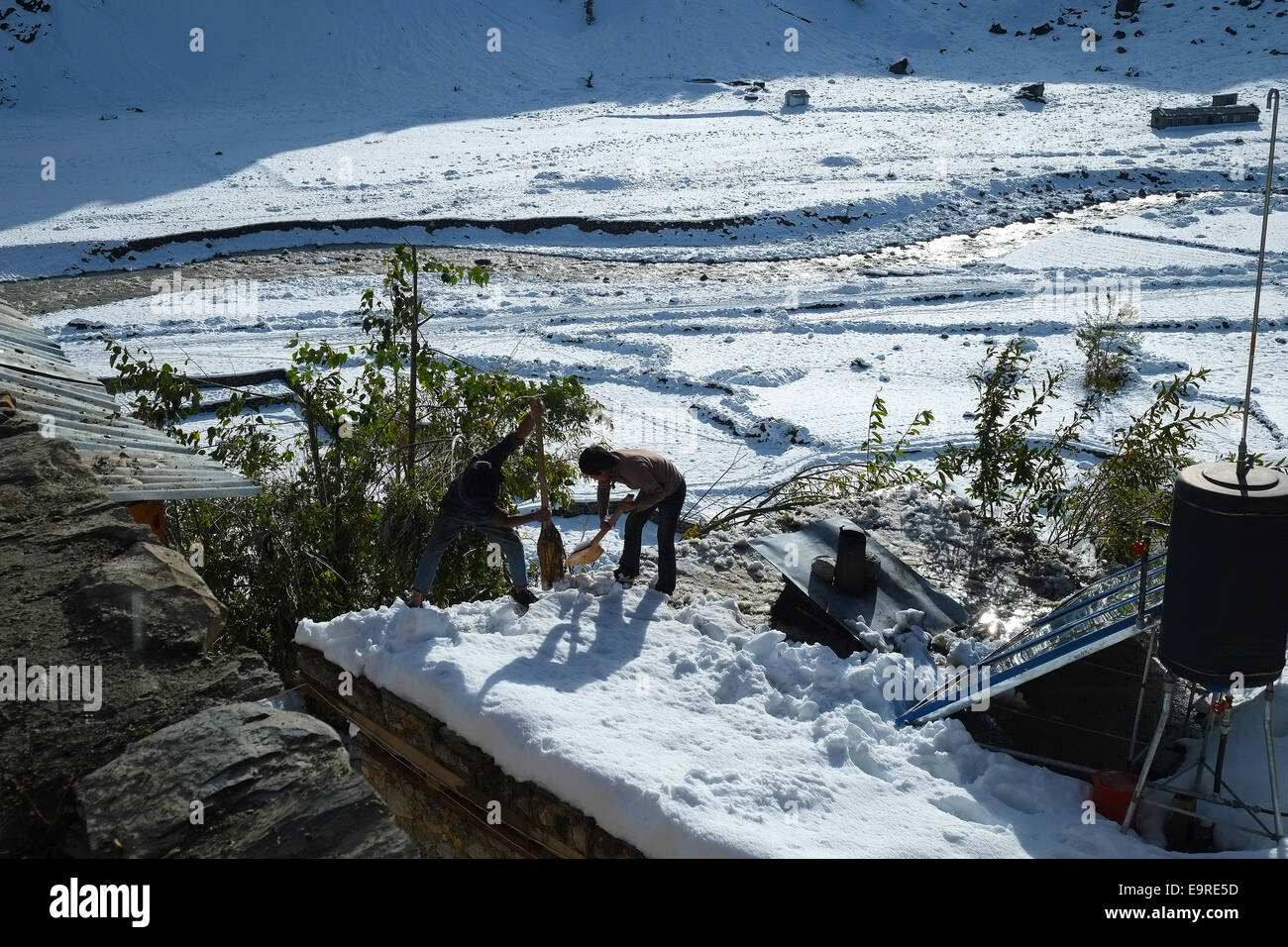 Clearing the roof from snow, Manang Stock Photo Alamy