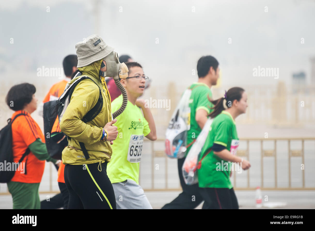 A runner wears a gas mask during the 2014 Beijing Marathon Stock Photo